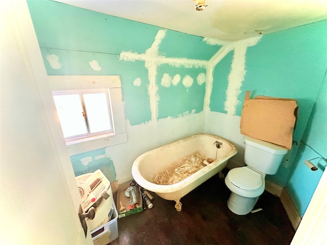 bathroom with a bathtub, wood-type flooring, and toilet