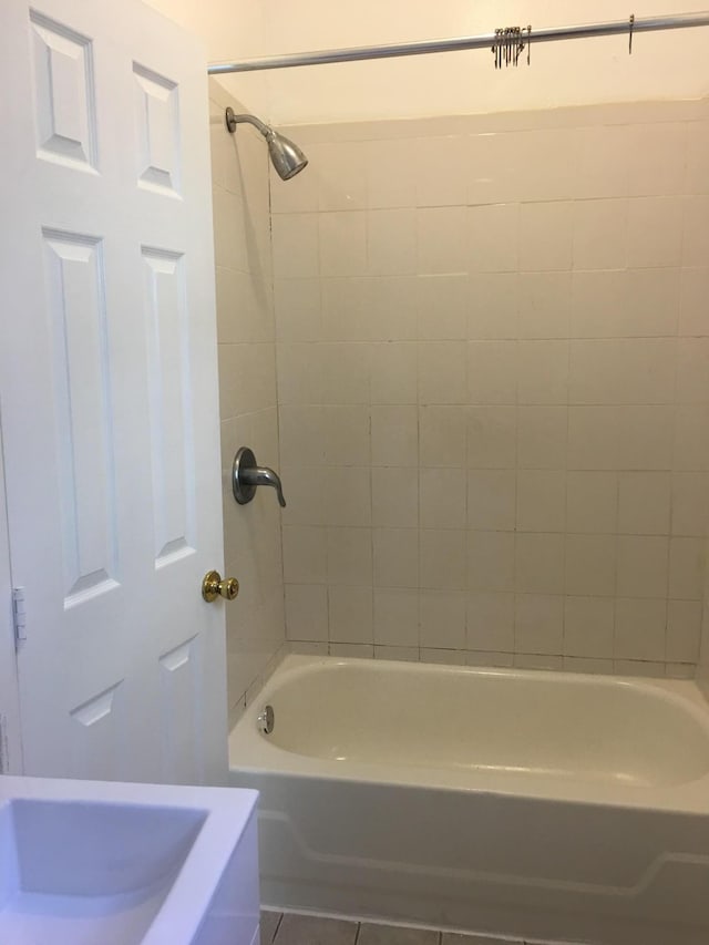 bathroom with tiled shower / bath combo and tile patterned flooring