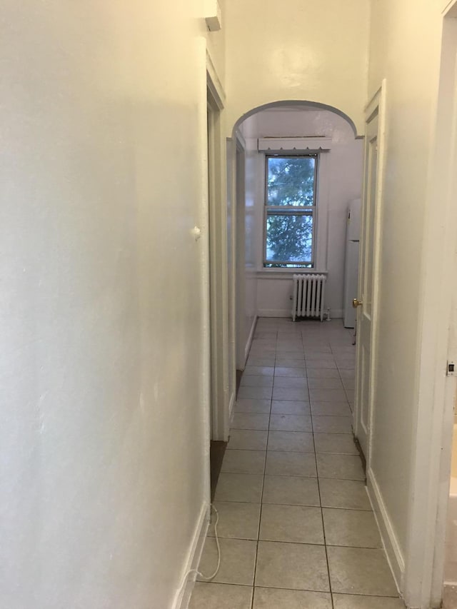 hallway featuring radiator and light tile patterned floors