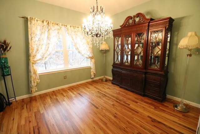 dining area with an inviting chandelier and hardwood / wood-style flooring