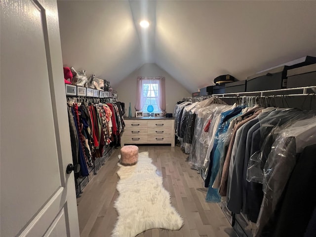 walk in closet with light hardwood / wood-style flooring and vaulted ceiling