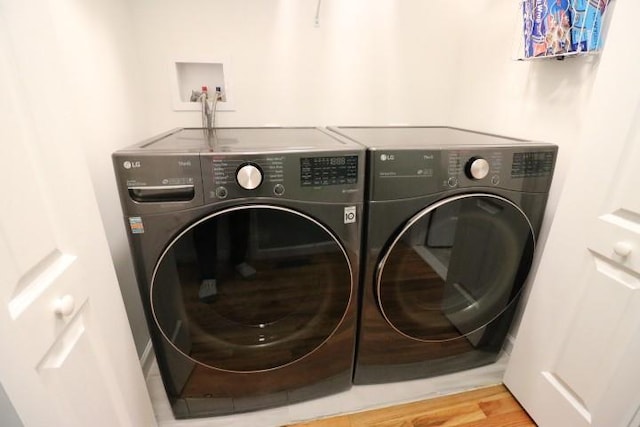 washroom featuring separate washer and dryer and wood-type flooring