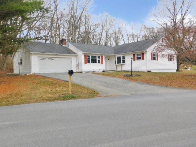 ranch-style home with a garage and a front lawn