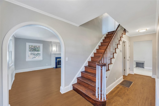 staircase featuring hardwood / wood-style flooring and crown molding