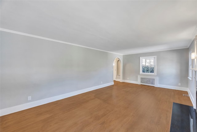 unfurnished living room with wood-type flooring and crown molding