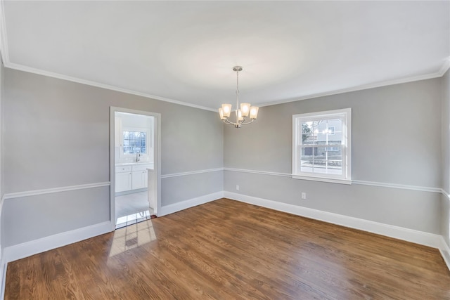 spare room with wood-type flooring, an inviting chandelier, ornamental molding, and sink