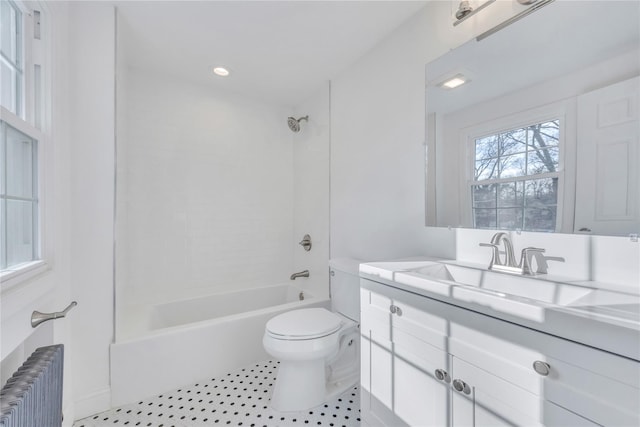 full bathroom with vanity, radiator heating unit, tiled shower / bath, and toilet