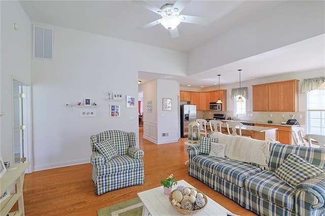 living room with light wood-type flooring and ceiling fan