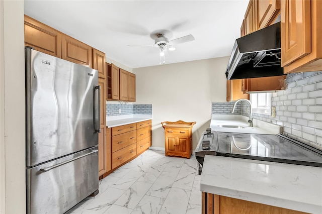 kitchen with tasteful backsplash, stainless steel fridge, sink, and ceiling fan