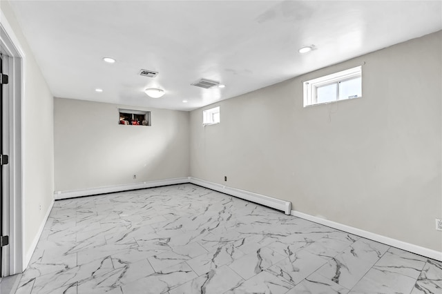 basement featuring marble finish floor, baseboards, and visible vents