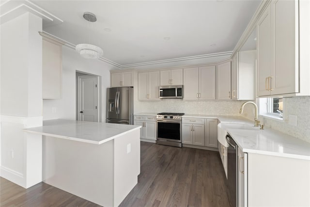 kitchen featuring sink, stainless steel appliances, dark hardwood / wood-style flooring, kitchen peninsula, and pendant lighting