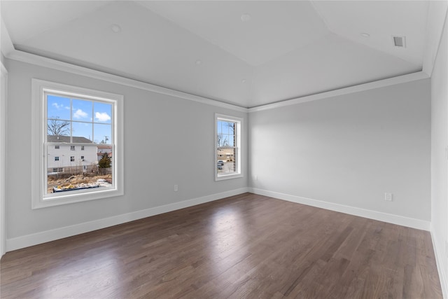 empty room featuring dark hardwood / wood-style flooring, a tray ceiling, and ornamental molding