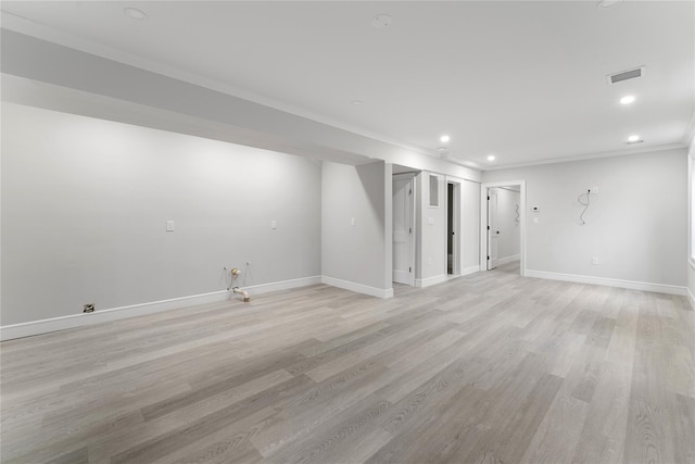 basement featuring crown molding and light hardwood / wood-style flooring