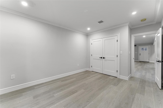 unfurnished bedroom featuring light hardwood / wood-style flooring, a closet, and ornamental molding