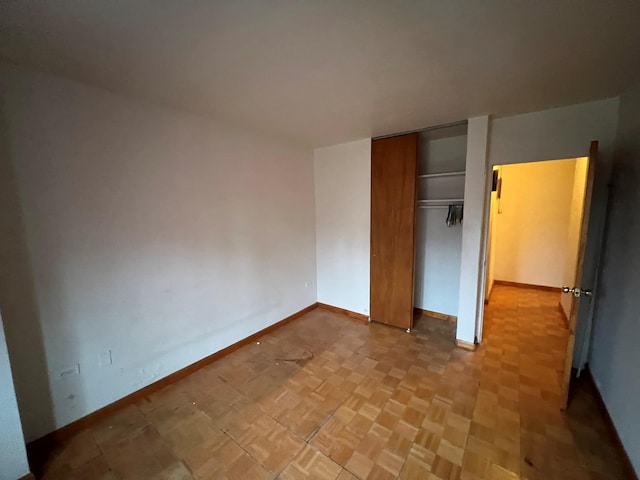 unfurnished bedroom with light parquet floors and a closet