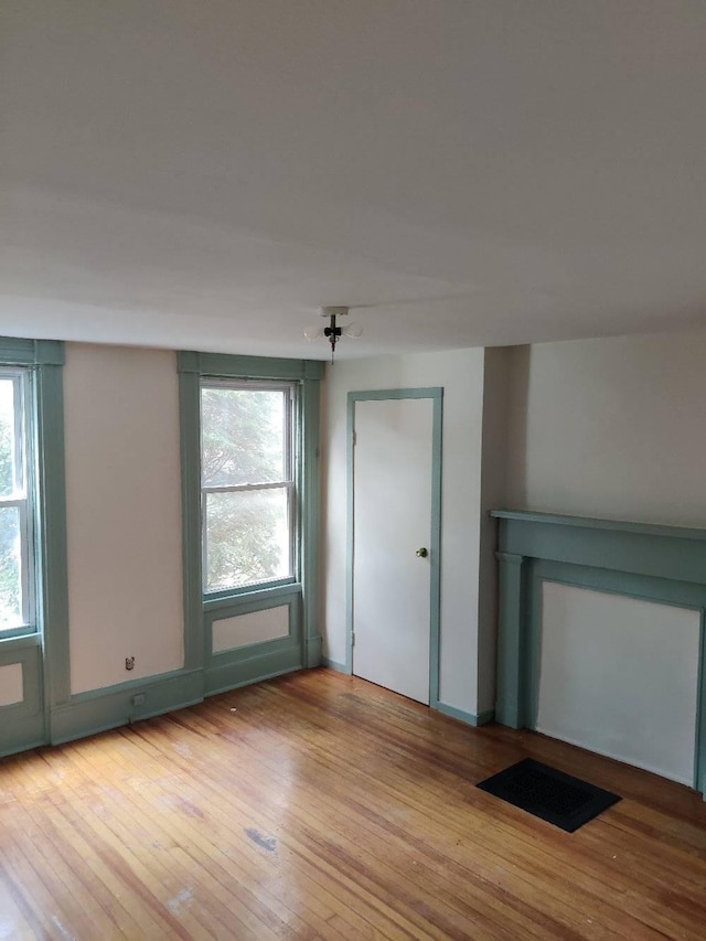 unfurnished room featuring light wood-type flooring and a wealth of natural light