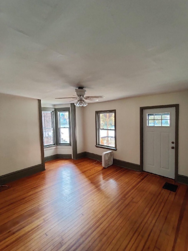 foyer entrance with ceiling fan and light hardwood / wood-style floors