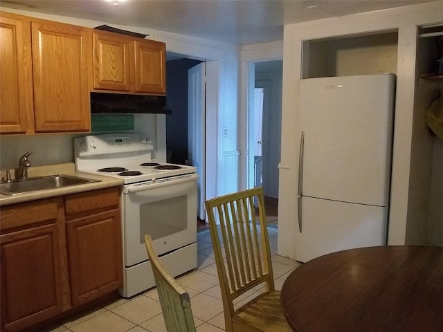 kitchen featuring sink, light tile patterned floors, and white appliances