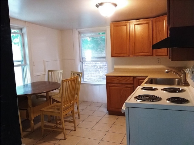 kitchen featuring light tile patterned floors, electric stove, a healthy amount of sunlight, and sink