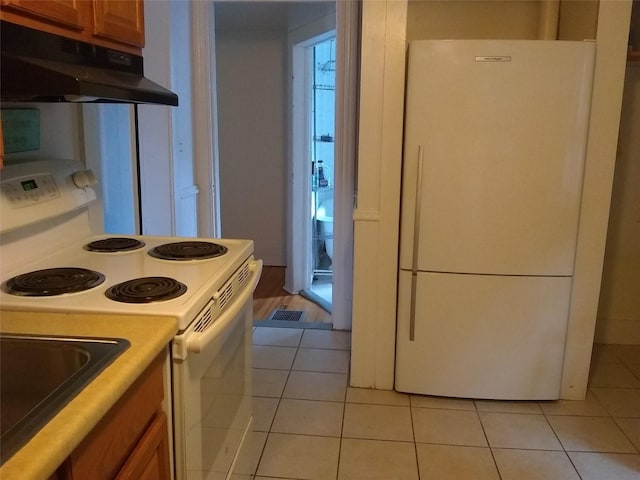 kitchen featuring white appliances and light tile patterned flooring