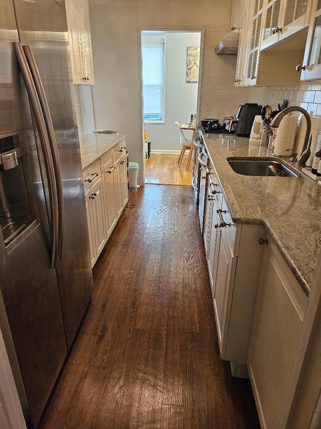 kitchen with sink, dark hardwood / wood-style flooring, light stone countertops, and stainless steel refrigerator with ice dispenser