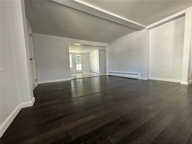 spare room featuring dark hardwood / wood-style floors and a baseboard heating unit