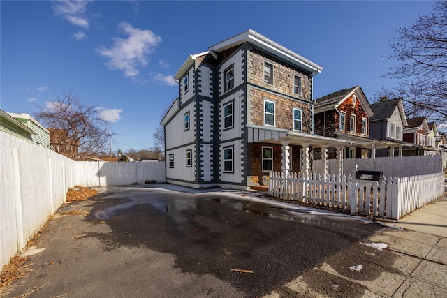 rear view of property featuring covered porch