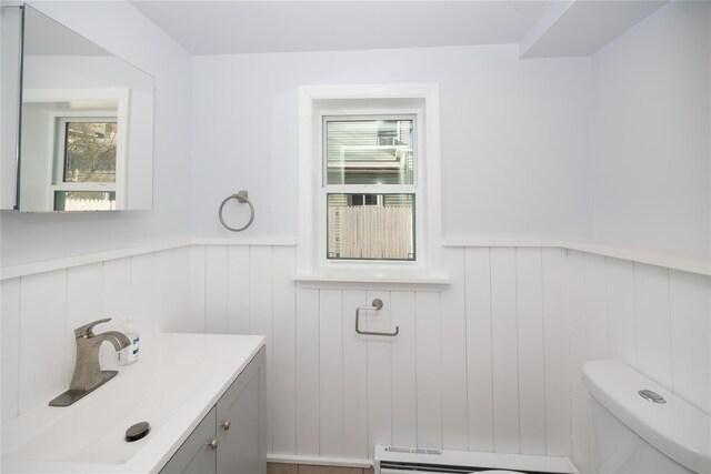 bathroom featuring vanity, a baseboard heating unit, and toilet