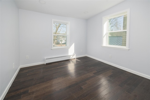 unfurnished room featuring dark hardwood / wood-style flooring and a baseboard heating unit