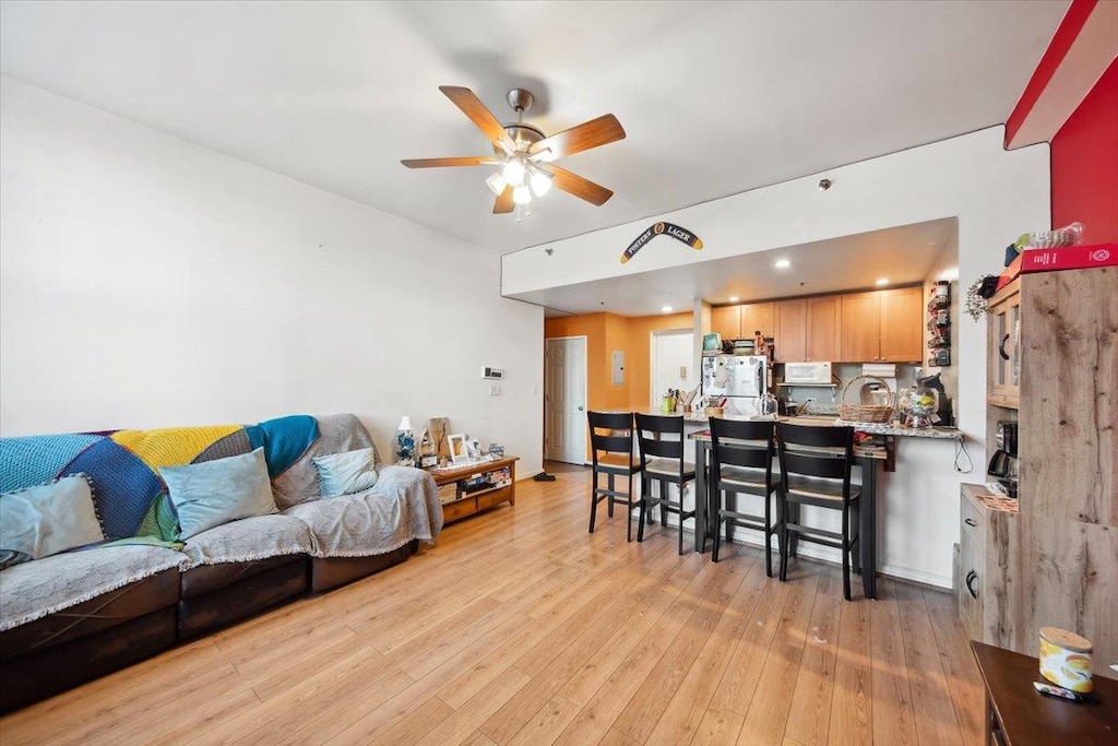 living room with ceiling fan and light wood-type flooring