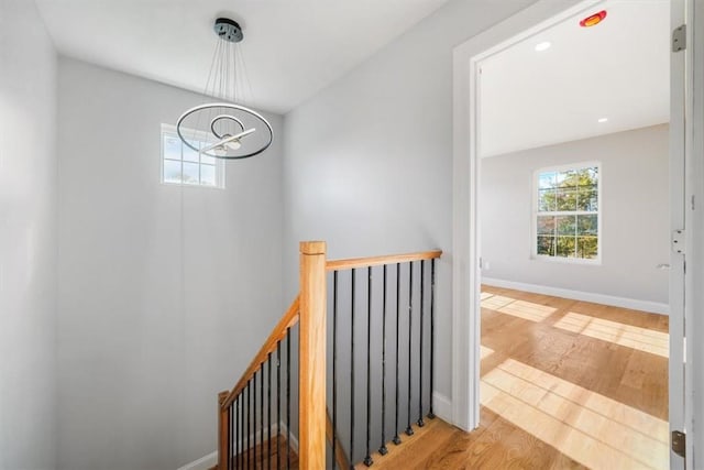 staircase featuring an inviting chandelier and hardwood / wood-style floors