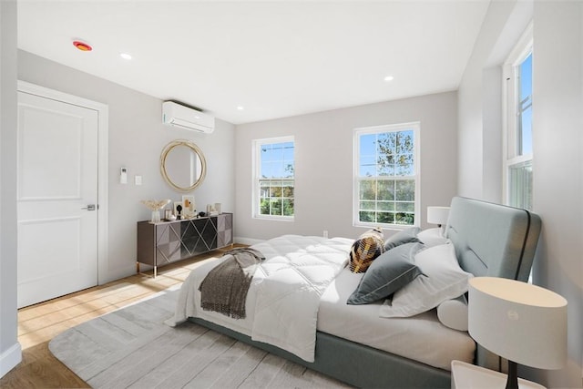 bedroom with an AC wall unit and wood-type flooring