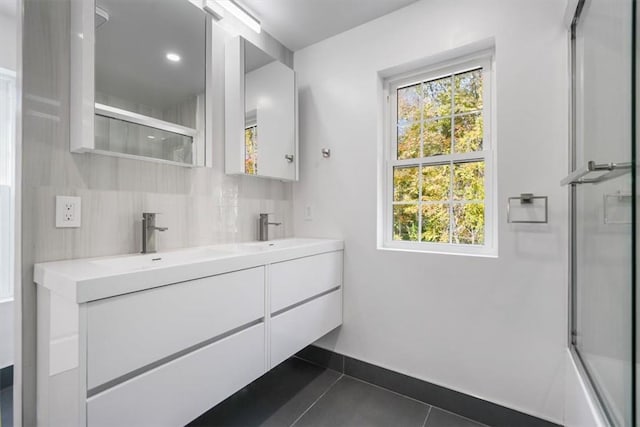 bathroom featuring decorative backsplash, shower / bath combination with glass door, vanity, and tile patterned flooring