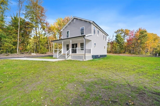 back of property featuring covered porch and a yard