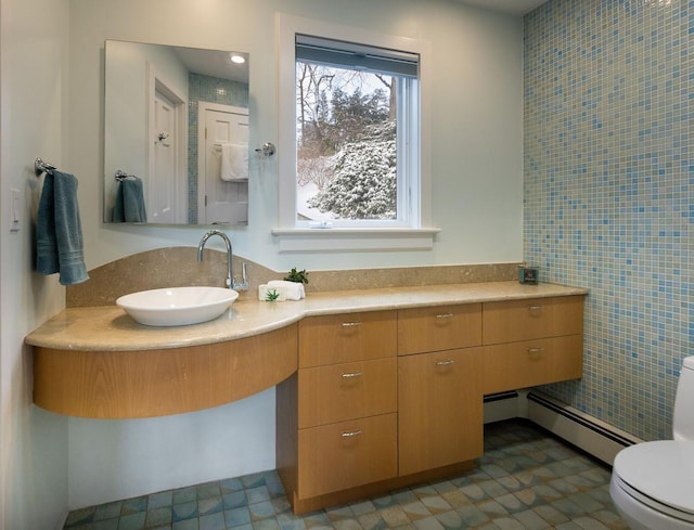 bathroom featuring baseboard heating, vanity, and toilet