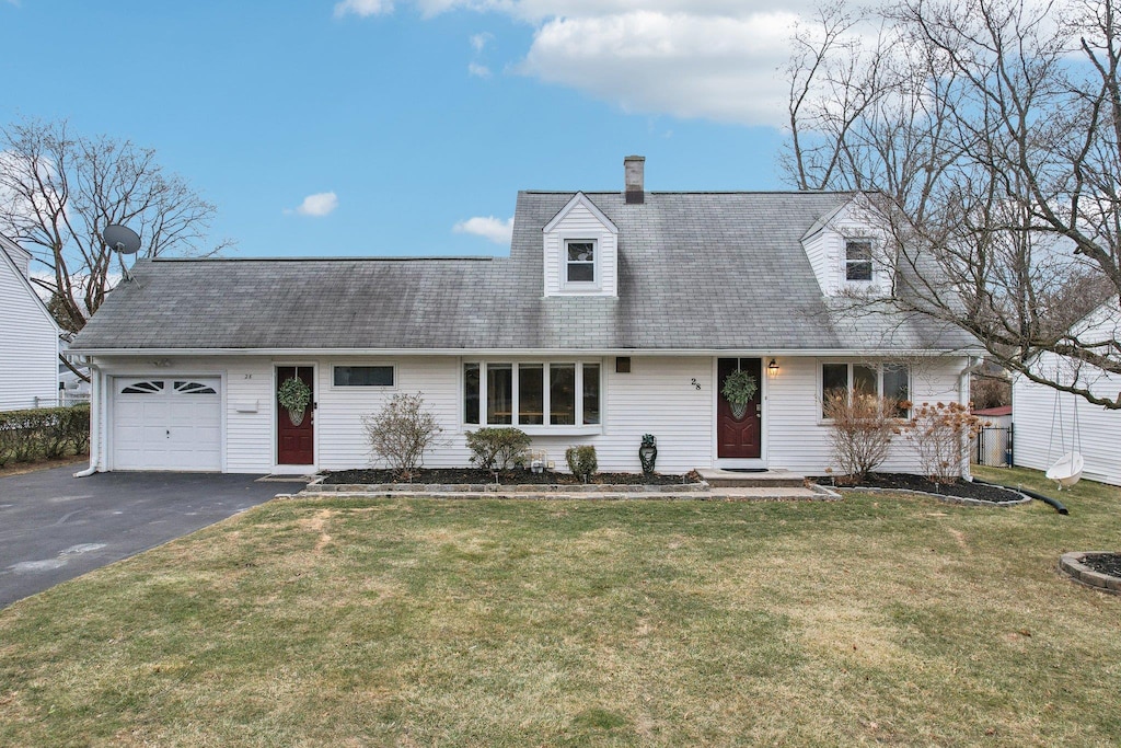 cape cod home with a garage and a front lawn