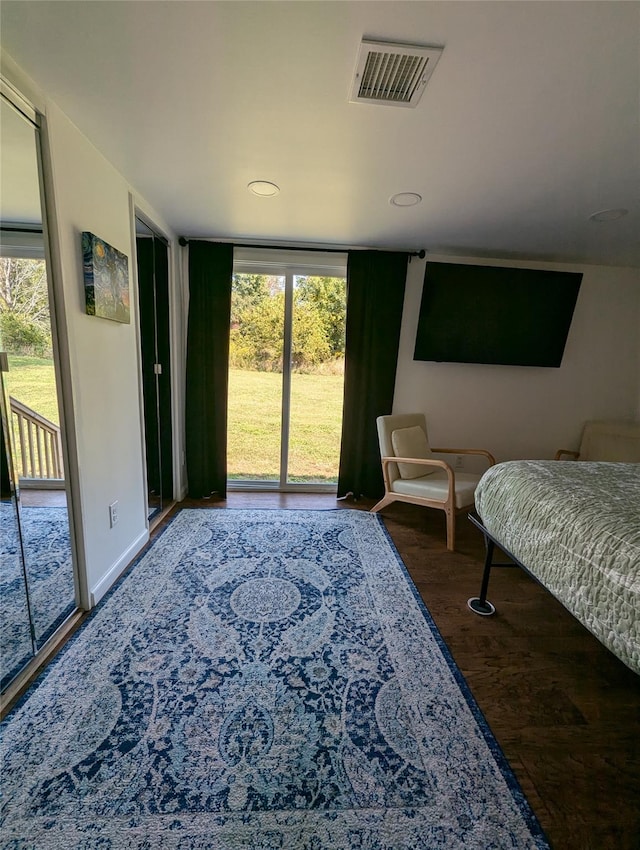 bedroom featuring dark hardwood / wood-style flooring, access to outside, and expansive windows