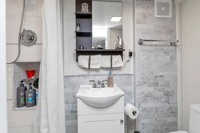 bathroom featuring a shower with curtain, vanity, tile walls, and toilet