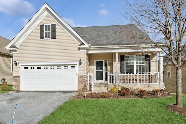 view of front of property featuring a porch, a garage, and a front yard