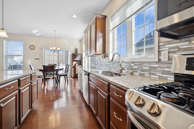 kitchen featuring pendant lighting, a chandelier, gas range oven, and dishwasher