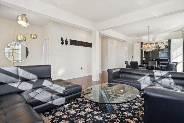 living room with hardwood / wood-style flooring, crown molding, and a notable chandelier