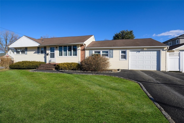 ranch-style home with a garage and a front lawn