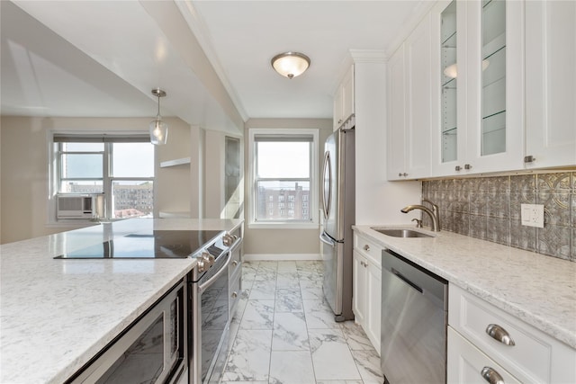 kitchen featuring light stone countertops, stainless steel appliances, sink, decorative light fixtures, and white cabinets