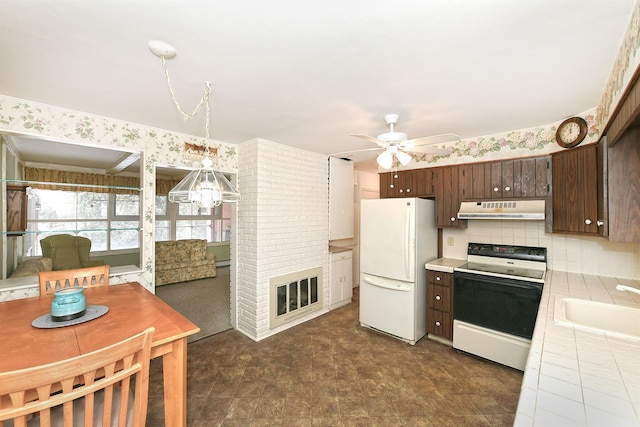 kitchen featuring electric range oven, tile counters, white fridge, sink, and dark brown cabinets