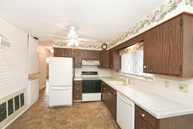 kitchen with tile countertops, decorative backsplash, white appliances, dark brown cabinetry, and sink