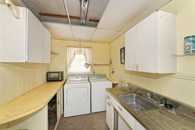 laundry area featuring sink, separate washer and dryer, and cabinets