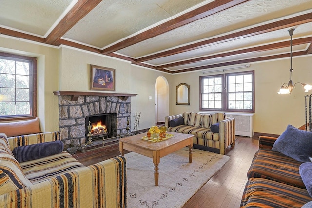 living room with dark wood-type flooring, a fireplace, beamed ceiling, a textured ceiling, and a chandelier