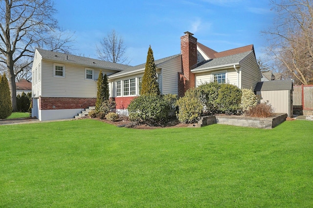 back of house featuring a yard and a storage shed