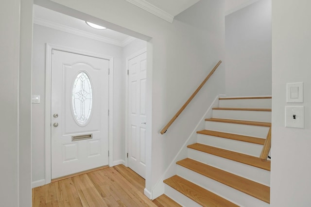 entryway featuring ornamental molding and wood-type flooring