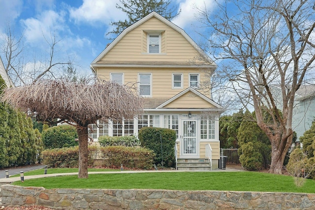 view of front facade featuring a gambrel roof and a front lawn